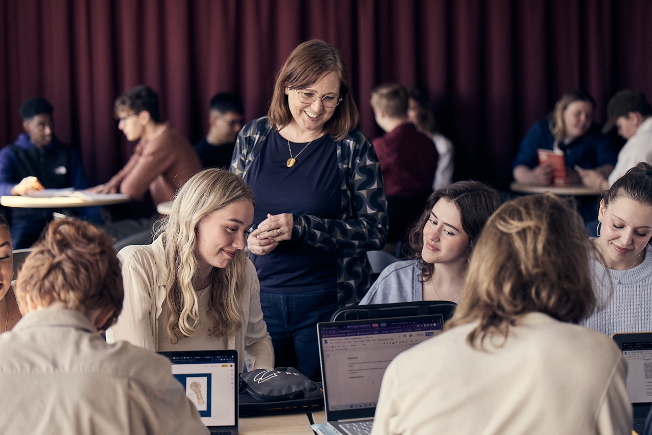 Lärare och elever samtalar och arbetar tillsammans i ett klassrum